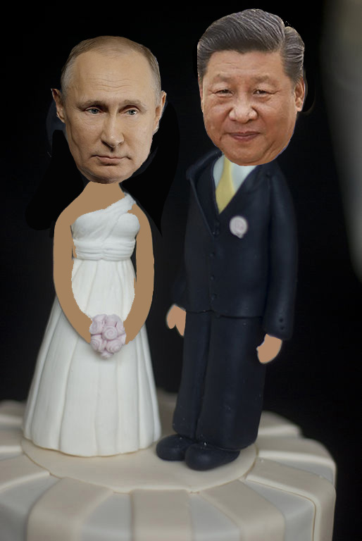 Image is a wedding cake topper with Vladimir Putin's head on the bride's body and Xi Jinping's head on the groom's body.