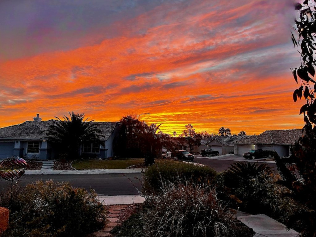 Colorful sunrise with a neighborhood in the foreground.