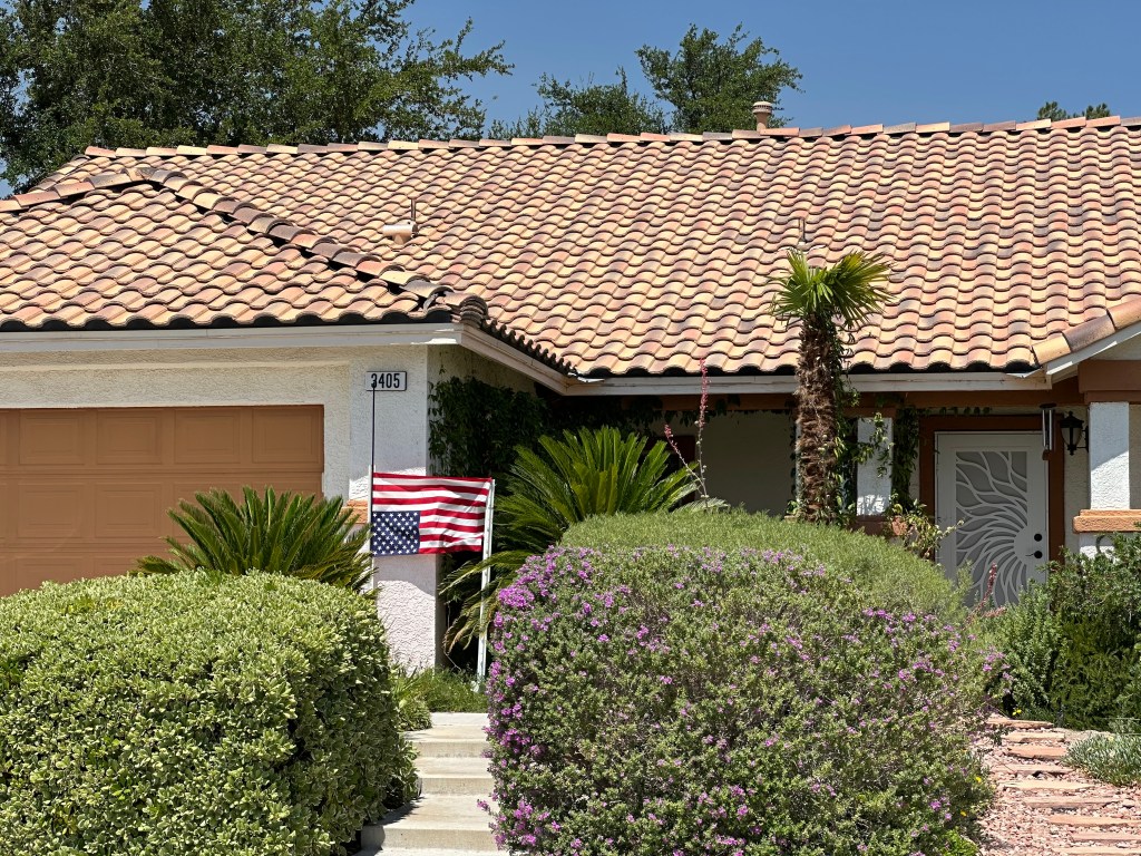 Photo of a house with an upside-down American flag in the front yard.